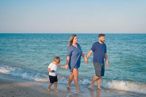 Mother father kid spending time together family vacation Parent dad mom walking with son enjoying sea beach photo