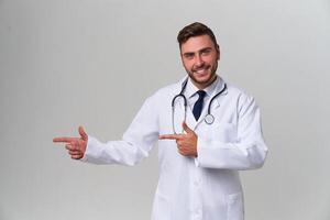 joven hermoso moderno médico en un blanco médico vestido soportes en el estudio en un blanco antecedentes. estudiante aprendiz de un médico universidad. foto