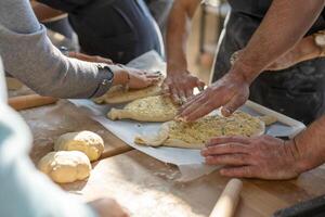 Culinary master class. Closeup of people hands preparing khachapuri. Traditional georgian cheese bread. Georgian food photo