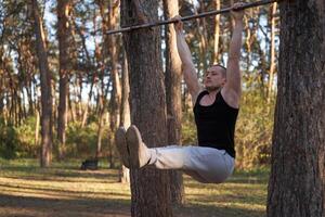 Handsome caucasian men pull-up outdoor workout cross training morning Pumping up arm exercising sports ground nature forest photo