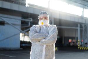 COVID-19 coronavirus doctor standing hospital parking dressed white protective overalls hazmat suit. photo