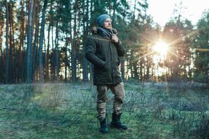 Portrait brutal bearded hipster man in the forest photo