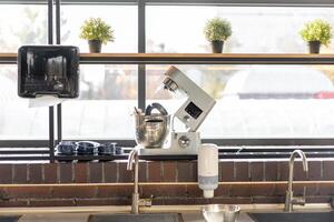 Disassembled multifunctional food processor in the kitchen by the window photo