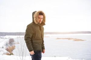 atractivo barbado hombre en pie al aire libre en invierno temporada bosque. foto