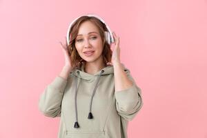 Woman listen music headphones  pink background studio shoot photo