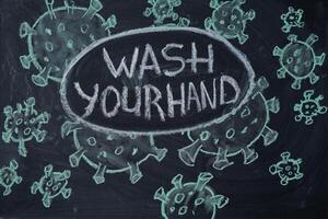 Wash your hand. Outbreak Warning. written white chalk on blackboard in connection with epidemic of coronavirus worldwide. photo