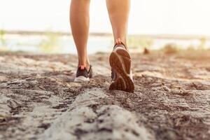 Close up of the legs of a young woman who is running off road in a park photo