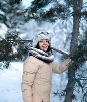 hermosa niña teniendo divertido en el invierno Nevado bosque foto