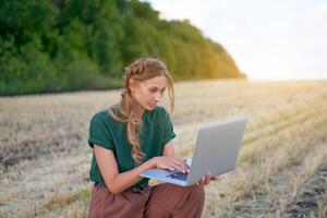 Woman farmer smart farming standing farmland smiling using laptop Female agronomist specialist research monitoring analysis data agribusiness photo