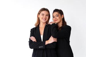 Concept of partnership in business. Two Young businesswoman dressed black formal suit standing studio isolated white background. photo