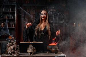 Halloween, witch use magic book and cauldron prepare poison or love potion photo