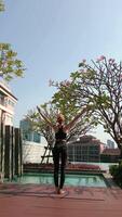 Woman practice yoga at the skyscraper's rooftop in a big city. video