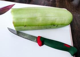 rebanado botella calabaza con cuchillo en el mesa foto