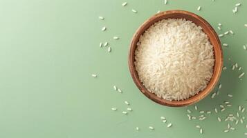 AI generated Bowl of uncooked white rice on a textured light green background. Top view. Concept of culinary staple, raw rice presentation, healthy food ingredient. Banner with copy space photo