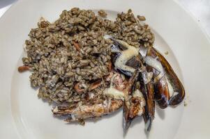 negro arroz con Mariscos en plato foto