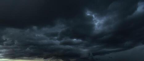 The dark sky with heavy clouds converging and a violent storm before the rain.Bad or moody weather sky and environment. carbon dioxide emissions, greenhouse effect, global warming, climate change photo