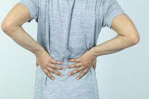 Man suffering from pain in the waist on a white background photo