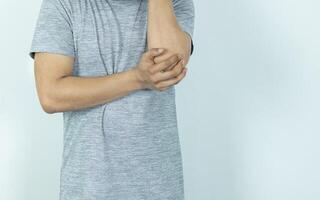 Man suffering from pain in elbow on white background photo