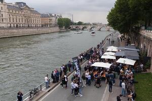 París, Francia 01 junio 2018 un compañero de joven personas bebidas y come en el bancos de el río jábega en el centrar de París. concepto picnic en el ciudad. cerveza entretenimiento fiesta foto