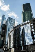 Detail blue glass building background with cloud sky photo