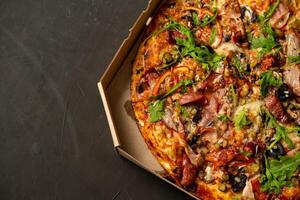 Appetizing pizza with smoked sausages bacon meat tomato cheese arugula photo