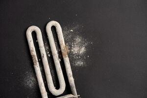 Damaged heating element of washing machine with scum and sediment photo