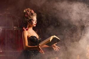 Charming woman witch flowers in hair vintage black dress with book of spell in the old castle. Halloween. Celebration. photo