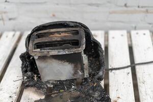 Burning toaster. Toaster with two slices of toast caught on fire over white background photo