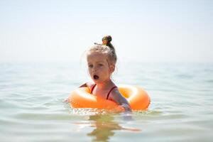 Child swims sea inflatable ring. danger of drowning Safety equipment, Child Life buoy photo