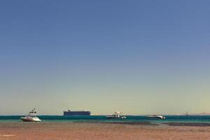 three yachts and a tanker in the sea bay photo