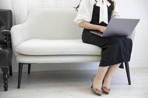 A Japanese woman typing laptop by remote work in the office faceless composition photo