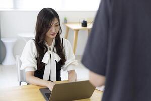 un trabajando japonés mujer con fotógrafo en el hogar oficina de cerca foto