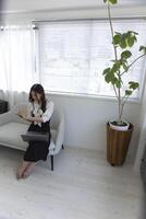 A Japanese woman checking smartphone by remote work in the small office photo