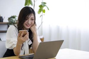 A Japanese woman checking smartphone by remote work in the small office photo