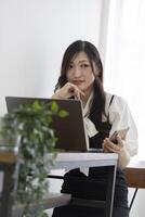 A Japanese woman checking smartphone by remote work in the small office photo