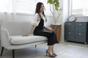 A Japanese woman checking smartphone by remote work in the home office photo