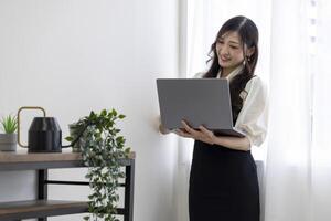 A Japanese woman checking smartphone by remote work in the home office photo