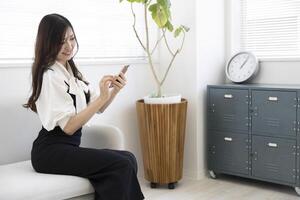 A Japanese woman checking smartphone by remote work in the home office photo