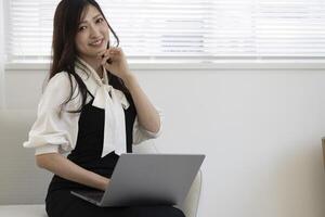 A working Japanese woman by remote work in the home office closeup photo