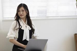 un trabajando japonés mujer por remoto trabajo en el hogar oficina de cerca foto