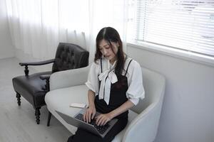 A Japanese woman checking smartphone by remote work in the home office photo