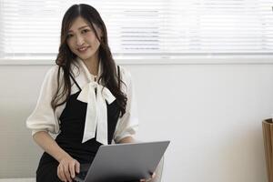 un trabajando japonés mujer por remoto trabajo en el hogar oficina de cerca foto