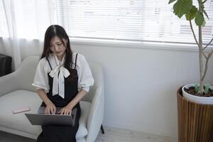 A Japanese woman checking smartphone by remote work in the home office photo