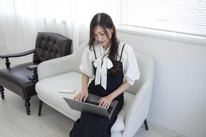 A Japanese woman checking smartphone by remote work in the home office photo