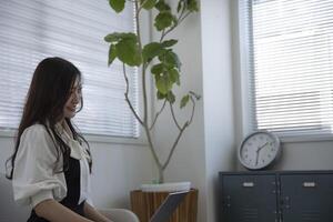 un trabajando japonés mujer por remoto trabajo en el hogar oficina de cerca foto