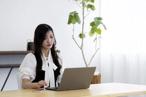 A working Japanese woman by remote work in the home office closeup photo