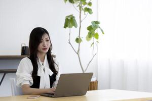 un trabajando japonés mujer por remoto trabajo en el hogar oficina de cerca foto