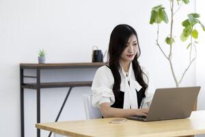 A working Japanese woman by remote work in the home office closeup photo