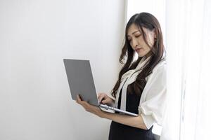 un trabajando japonés mujer por remoto trabajo en el hogar oficina de cerca foto