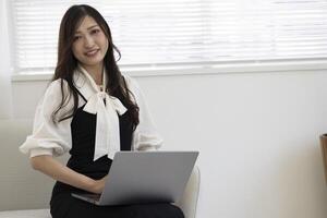 A working Japanese woman by remote work in the home office closeup photo